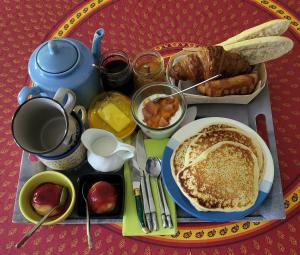 a breakfast tray with pancakes and other breakfast foods at La troglodyte in Sérignan-du-Comtat