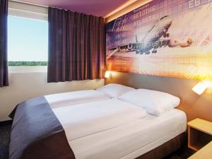 a bedroom with a bed with a poster on the wall at B&B Hotel Frankfurt-Airport in Frankfurt/Main