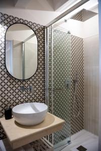 a bathroom with a sink and a shower with a mirror at Luxury B&B Maison Madre in the historic center of Avola in Avola