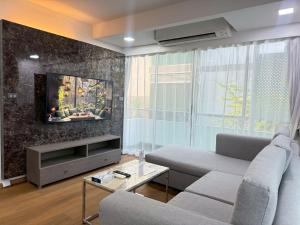 a living room with a couch and a tv at Civic Park in Bangkok
