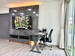 an office with a desk and a tv on a wall at Civic Park in Bangkok