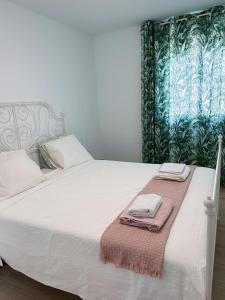 a bedroom with a white bed with two towels on it at Villa Lele in Playa Blanca