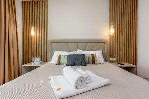 a hotel room with a bed with towels on it at Relax Blue VOGH in Olimp