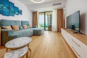 a living room with a blue couch and a flat screen tv at Relax Blue VOGH in Olimp