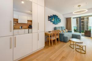 a kitchen and living room with white cabinets and a table at Relax Blue VOGH in Olimp
