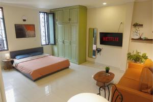 a bedroom with a bed and a couch at Migo Housing - Lift Access - Hanoi Beer Street - Central and Spacious - Ensuite Kitchen - Ensuite Bathroom in Hanoi