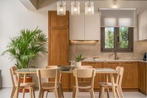 a kitchen with a table and chairs in a kitchen at Hariati Villas - An Elegant Escape, by Zantewize in Kipseli
