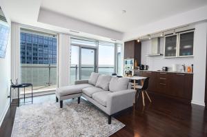 ミシサガにあるDowntown Toronto Condo walk to CN Tower and Rogers centerのソファとキッチンのあるリビングルーム