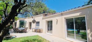 une maison avec un patio avec une table et des chaises dans l'établissement La Maison du Soleil, à Saint-Didier