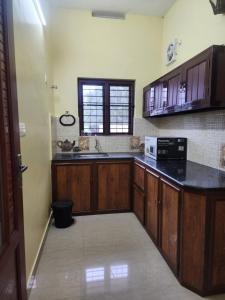 Una cocina con gabinetes de madera y una encimera negra. en Rock Villa, en Vagamon