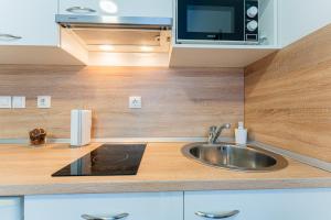 a kitchen with a sink and a microwave at Flex SelfCheckIns 130 - Zagreb - Studio Apartment - Center in Zagreb