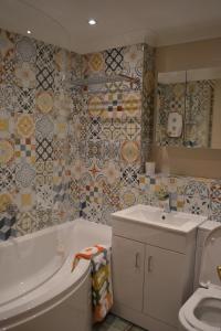 a bathroom with a tub and a sink and a toilet at Marina Flat, Swansea - Perfect Location in Swansea