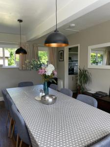 a dining room table with blue chairs and flowers on it at The Gillett's Cottage in Wantage