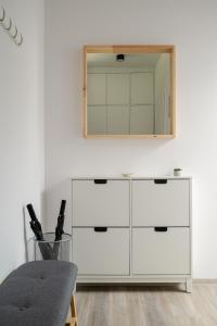 a white dresser with a mirror on a wall at Apartmány v Rezidenci Podhradí in Štramberk