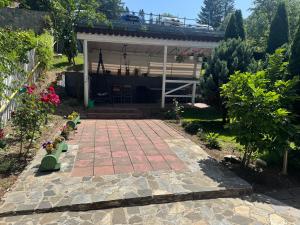 a house with a brick walkway in the yard at Pensiunea Crescent Predeal in Predeal