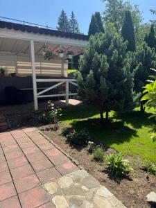 a garden with two pine trees and a pavilion at Pensiunea Crescent Predeal in Predeal