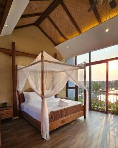 une chambre avec un lit à baldaquin dans l'établissement Biệt Thự Hội An View, à Thanh Ðông (1)