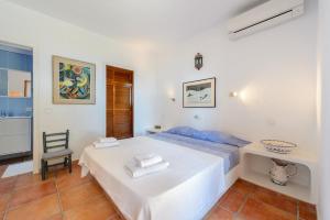 een witte slaapkamer met een bed en een stoel bij amazing villa in Es Cubells +69 foto's