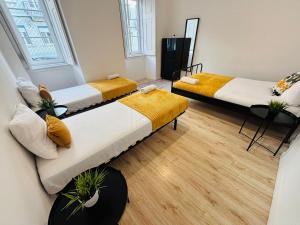 リスボンにあるLuxury rooms in Lisbon city centre top locationの木製の床の部屋にベッドが2つあります