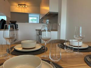 a wooden table with wine glasses and plates on it at Ferienwohnungen Vito's Apartments Ravensburg in Ravensburg