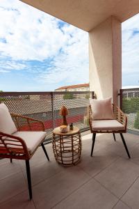 a patio with two chairs and a table on a balcony at ARI - AFI Mall Luxurious Apartments with Free Parking in Arad +282 photos