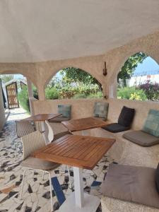 a patio with tables and chairs and a table at Plage Blue Lagoon - Villa with Pool & Ocean Access in Warang