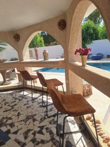 a patio with chairs and a swimming pool at Plage Blue Lagoon - Villa with Pool & Ocean Access in Warang +81 photos