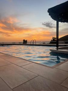 a swimming pool with a sunset in the background at Apartamento Frente al Mar in Santa Marta