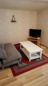 a living room with a couch and a coffee table at Studio meublé in Le Mans