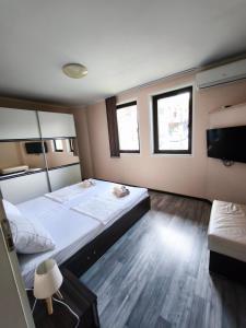 a bedroom with two beds and a flat screen tv at Royal Apartment-Veliko Tarnovo in Veliko Tŭrnovo