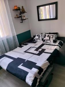a bedroom with a bed with black and white sheets at Simplicité, efficacité, convivialité ! in Dreux