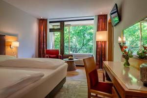 a hotel room with a bed and a desk at Dolce by Wyndham Bad Nauheim in Bad Nauheim