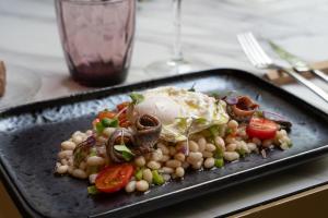 a black plate of food with an egg on top at Catalonia Eixample 1864 in Barcelona +39 photos