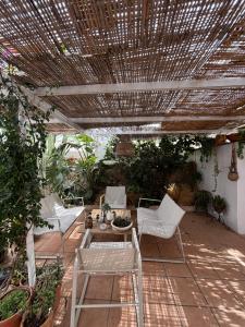 ニハルにあるLa casita Azulの白い椅子とテーブル、木製の天井のあるパティオ