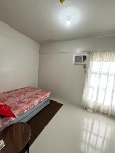 a small room with a bed and a window at RCL Homestay condo unit in Mactan Island