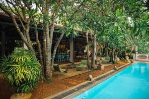 a resort with a swimming pool and palm trees at Ginganga Lodge in Galle