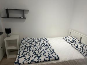 a bed with a black and white comforter and pillows at Powidz Cozy Apartament in Powidz