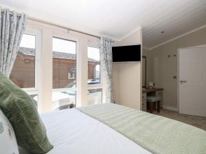 a bedroom with a bed and a large window at Life's a Beach in Norwich