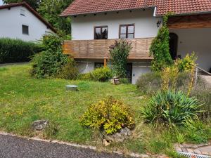a house with a yard with flowers and plants at Sonnige Souterrain-Einliegerwohnung im Herzen Parsbergs in Parsberg