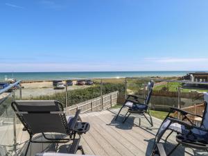 a deck with chairs and a view of the beach at Life's a Beach in Norwich