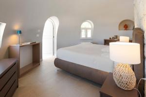 a bedroom with a bed and a table with a lamp at Villa del Mito in Plemmirio