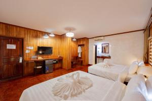 a hotel room with two beds and a television at LUANGPRABANG CENTER Hotel in Luang Prabang
