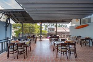 a restaurant with tables and chairs on a balcony at LUANGPRABANG CENTER Hotel in Luang Prabang