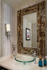 a bathroom with a glass sink and a mirror at The Woodlands Waterway Marriott Hotel and Convention Center in The Woodlands