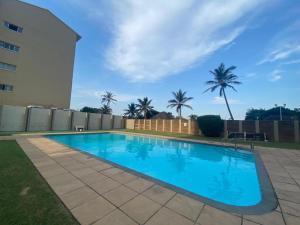 basen w ogrodzie obok budynku w obiekcie Beach Front Holiday Apartment, Stella Maris, Beach Road, Amanzimtoti w mieście Amanzimtoti