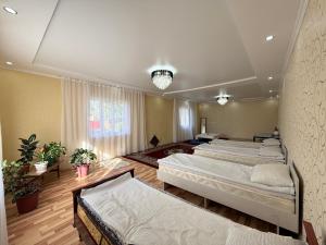a room with four beds in it with a window at Dan guest house in Pokrovka