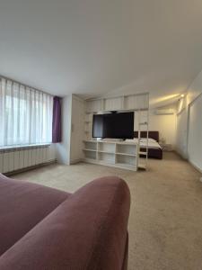 a room with a bed and a flat screen tv at Apartament Magnolia Nearby City Center With Parking in Sibiu