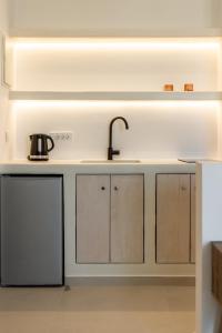 a kitchen with white cabinets and a sink at Aloni Suites Pollonia in Pollonia