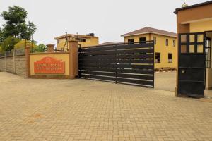 a black fence with a sign in front of a building at Lake Naivasha Lazarus Lodge in Naivasha