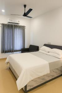 a bedroom with a large bed and a ceiling fan at The Nest in Trichūr +3 photos